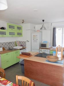 une cuisine avec des placards verts et un comptoir dans l'établissement Chez Marianne, à Quiberon