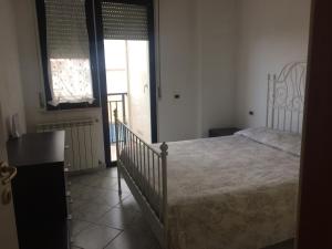 um quarto com uma cama e uma porta para uma varanda em Roseto degli Abruzzi Fronte Mare em Roseto degli Abruzzi