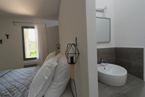 a white bedroom with a bed and a sink at Les Lodges du Pic in Saint-Jean-de-Cuculles