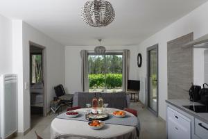 una cocina y una sala de estar con una mesa con naranjas. en Les Lodges du Pic en Saint-Jean-de-Cuculles