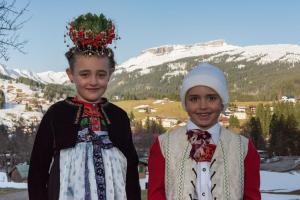 two young girls in traditional clothing standing in front of a mountain at Gästehaus Margit Ott in Riezlern