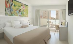 a white bedroom with a large white bed and a desk at Hotel Villa Luz in Gandía