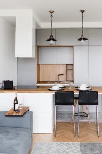a kitchen with a table and two chairs and a counter at LuxLux Apartments Silver Dove in Warsaw