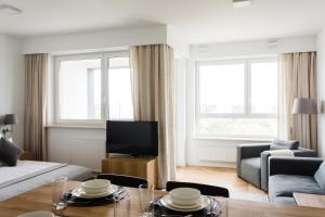 ワルシャワにあるLuxLux Apartments Silver Doveのリビングルーム(ソファ、テーブル付)