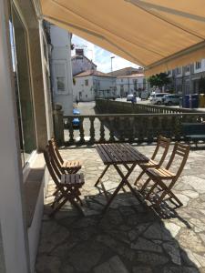 two wooden chairs and a table on a patio at Albergue Porta Real NO BIKE STORAGE in Santiago de Compostela