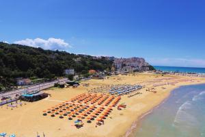 una vista panoramica su una spiaggia con ombrelloni e persone di Park Hotel Villa Americana a Rodi Garganico