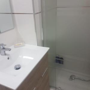 y baño blanco con lavabo y ducha. en Estudio romántico en Puerto De Navacerrada en Cercedilla