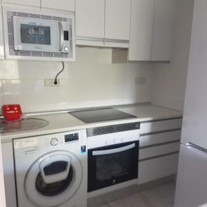 a kitchen with a washing machine and a microwave at Estudio romántico en Puerto De Navacerrada in Cercedilla