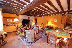 a living room with a table and some chairs at La Faisanderie in Grandcamp-Maisy