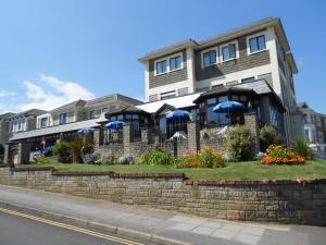 un grande edificio con ombrelloni blu davanti di The Wight Bay Hotel - Isle of Wight a Sandown