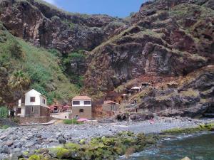 a group of buildings on the side of a mountain at Sea View House in Ribeira Brava