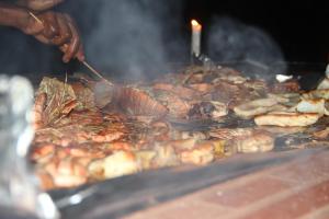 a person cooking a bunch of food on a grill at Mangrove Lodge in Zanzibar City