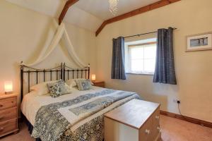 Un dormitorio con una cama grande y una ventana en Tregolls Farm Cottages, en Wadebridge