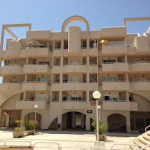 a large building with chairs in front of it at 1 Calle del Mar Apartamento in Garrucha