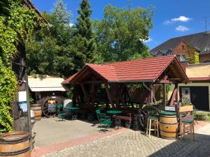 a pavilion with a red roof and chairs and barrels at Brauhaus und Pension Babben in Lübbenau