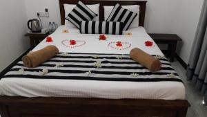 ein Bett mit schwarzen und weißen Decken und Kissen in der Unterkunft Habarana New Star Homestay in Habarana