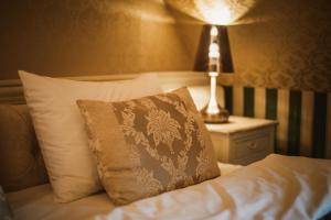 - un lit avec un oreiller et une lampe sur une table dans l'établissement Via Villa, à Nowe Kramsko
