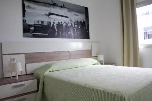 a bedroom with a bed with a picture on the wall at Apartamentos Tao Laia in Puerto del Rosario