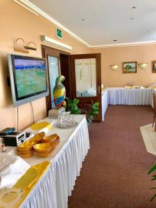 een kamer met witte tafels en een flatscreen-tv bij Hotel-Marks-Garni in Zingst