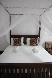 a bed in a tent with two towels on it at Sigiriya Lahiru Homestay in Sigiriya