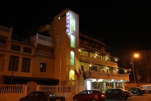 a building with a neon sign on it at night at Hotel Martini in Vlorë