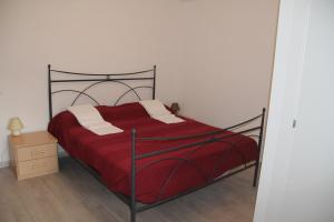 um quarto com uma cama com uma colcha vermelha em B&B Poggio di Balestrino em Balestrino
