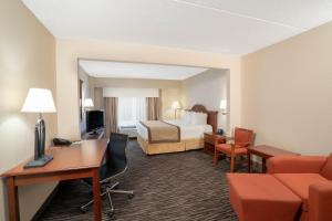 Habitación de hotel con cama y escritorio en Wingate by Wyndham Charlotte Airport, en Charlotte