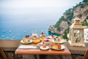 a tray of breakfast food on a table near the ocean at Hotel Villa Gabrisa in Positano