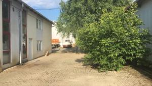 una calle vacía con un árbol al lado de un edificio en SepcoServ en Apahida