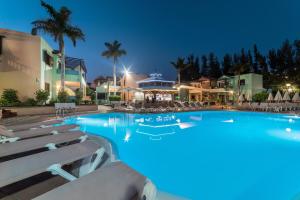 una gran piscina con sillas y un hotel en Club Vista Serena, en Maspalomas