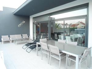 a dining room with white chairs and a table at casa Mariona in Riumar