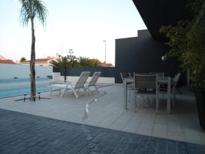 a table and chairs on a patio next to a pool at casa Mariona in Riumar