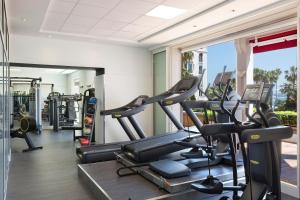 a gym with treadmills and elliptical machines at Hôtel Barrière Le Majestic Cannes in Cannes