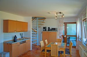 eine Küche und ein Esszimmer mit Tisch und Stühlen in der Unterkunft Seeblick 5 - Ruhig - Mönchgut in Ostseebad Sellin