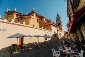 een groep tafels en stoelen met parasols voor een gebouw bij Comfortable- 2Bd 1Bth- Triana in Sevilla