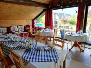 a dining room with tables and chairs and windows at Haus Tapestry in Nötsch