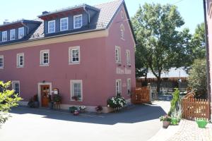 ein rosafarbenes Haus mit schwarzem Dach in der Unterkunft Altes -Haus in Gattendorf