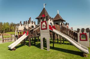 a playground with a castle slide in the grass at Hotel Nosalowy Dwór in Zakopane