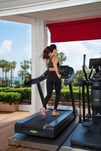 a woman on a treadmill in a gym at Hôtel Barrière Le Majestic Cannes in Cannes