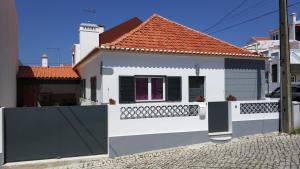 ein weißes Haus mit einem schwarzen und weißen Zaun in der Unterkunft Villa Sofia in Foz do Arelho