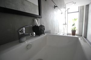 实兆远68 Boutique Hotel的浴室里有水龙头的白色浴缸