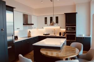 
a kitchen with a sink and a table at Modern luxury 2 bed with a view in St. Andrews
