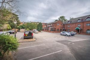 a parking lot with cars parked in front of brick buildings at Bridge House Hotel in Birmingham