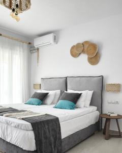a bedroom with a large bed with blue pillows at Angelos Boutique Suites in Patitiri