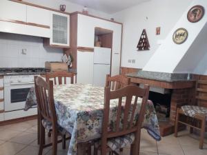 uma cozinha com uma mesa e cadeiras e uma lareira em Casa Elena em Amaroni