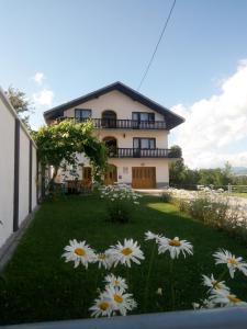 ein Haus mit einem Garten mit Blumen davor in der Unterkunft Holiday Home Nana in Bugojno