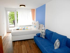 ein Schlafzimmer mit einem Bett und einem blauen Sofa in der Unterkunft Apartment Möwe in Meersburg