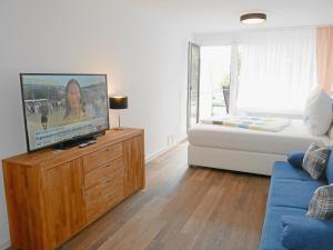 ein Wohnzimmer mit einem TV auf einer Holzkommode in der Unterkunft Apartment Möwe in Meersburg