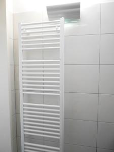 a white cabinet in a bathroom with white tiles at Apartment Möwe in Meersburg +15 photos