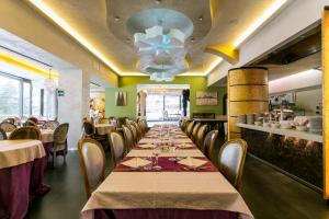 una lunga sala da pranzo con un lungo tavolo e sedie di Design Oberosler Hotel a Madonna di Campiglio